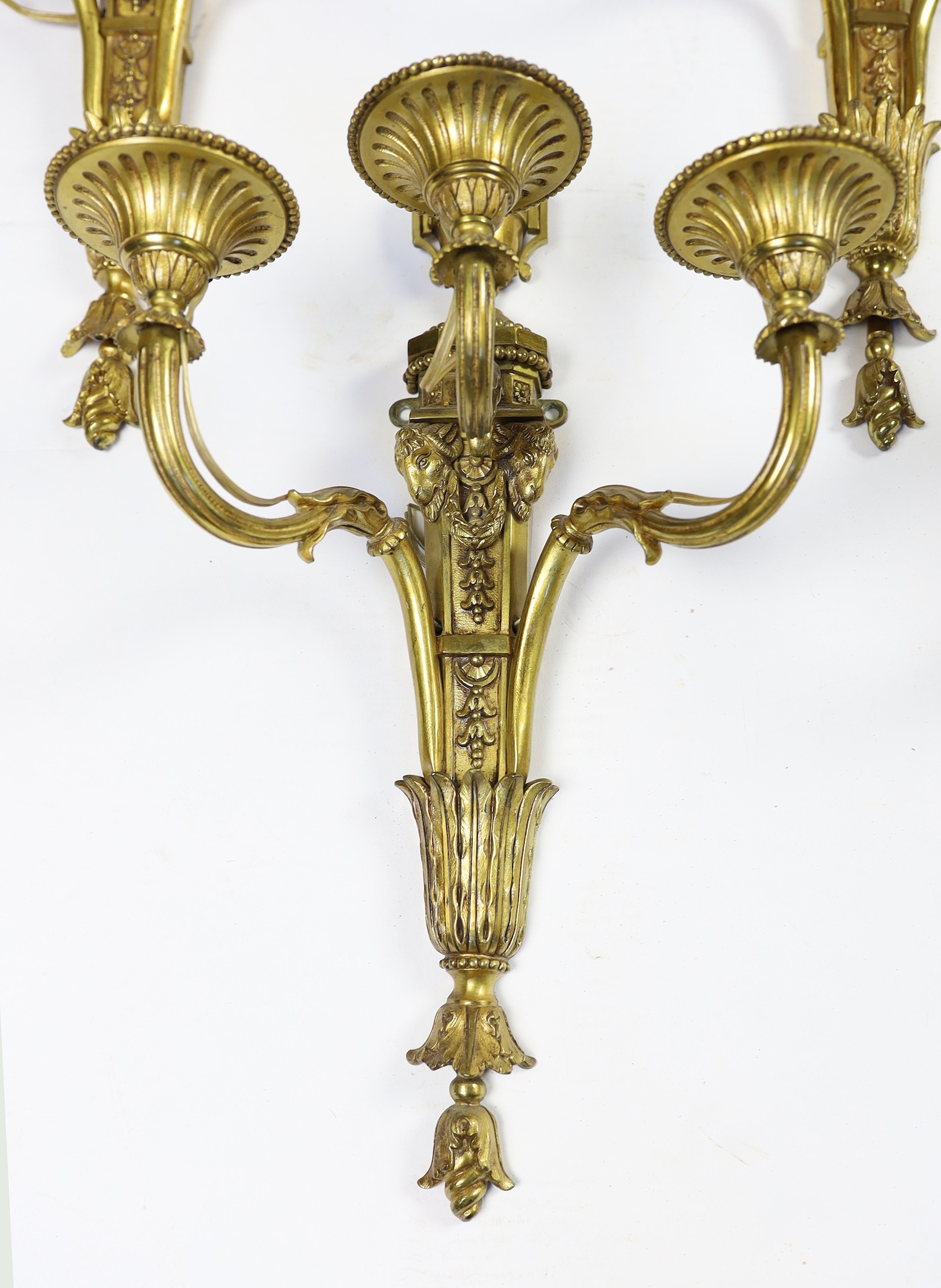 A set of eight cast gilt brass three branch wall sconces Height 23cm Width 22cm